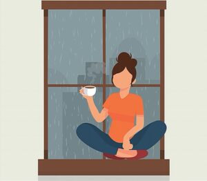 Woman sitting on window enjoying monsoon magic